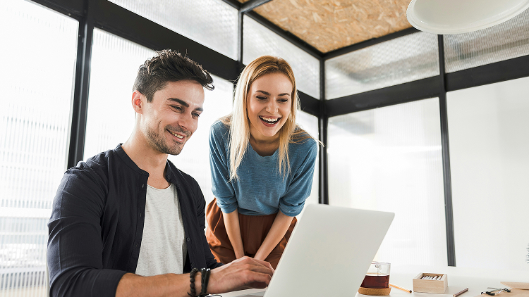 Caucasian co-workers looking at the computer monitor